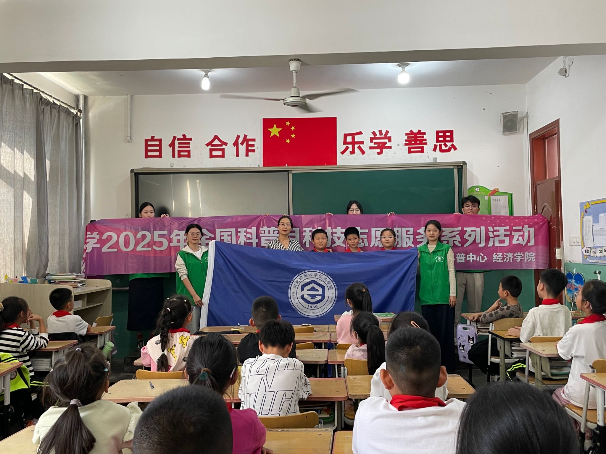 学生和志愿者与院旗、横幅合影.jpg